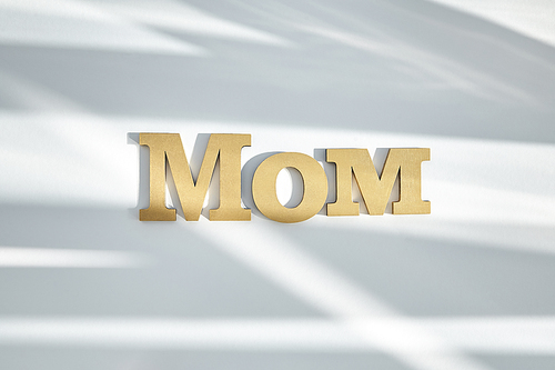 top view of mom lettering on white background with shadows