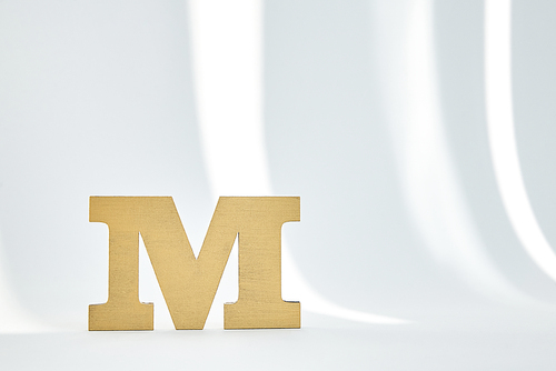 m letter on white background with sunlight
