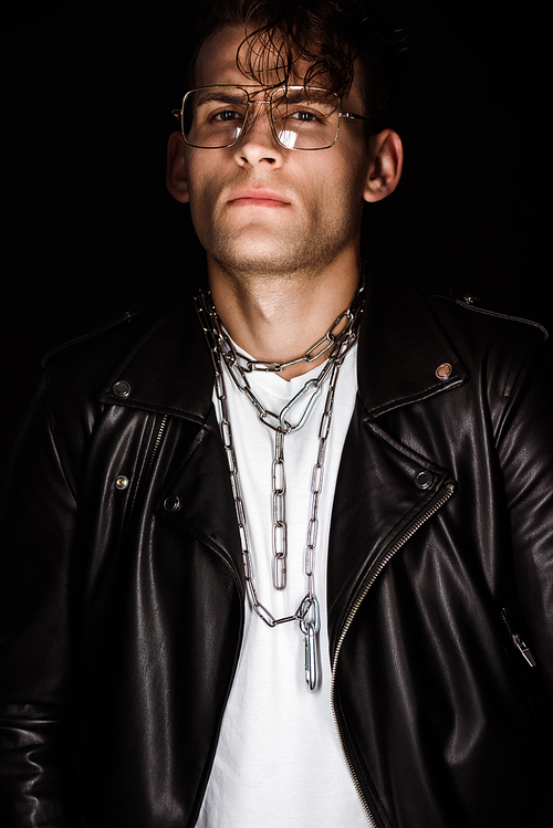 stylish man in glasses with chains on neck isolated on black