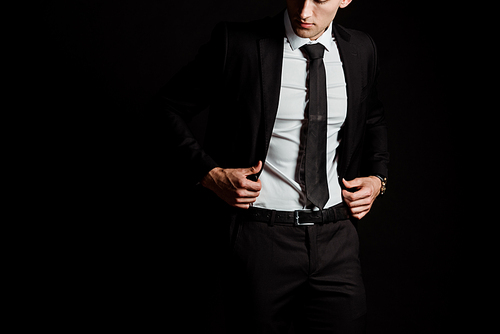 cropped view of man touching suit isolated on black