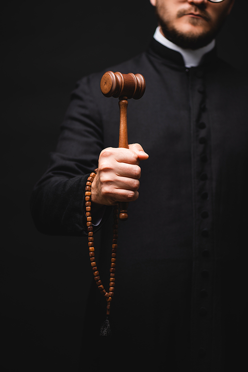 cropped view of priest holding wooden gavel and rosary beads isolated on black