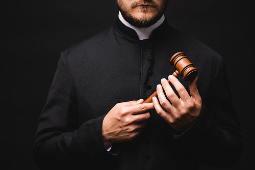 cropped view of bearded priest holding wooden gavel isolated on black