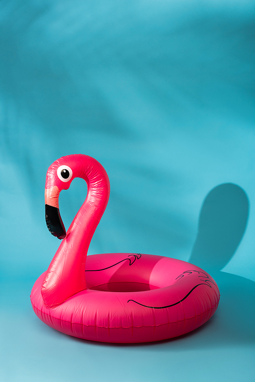 pink inflatable flamingo on blue background