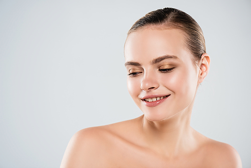 happy young woman smiling and looking away isolated on grey