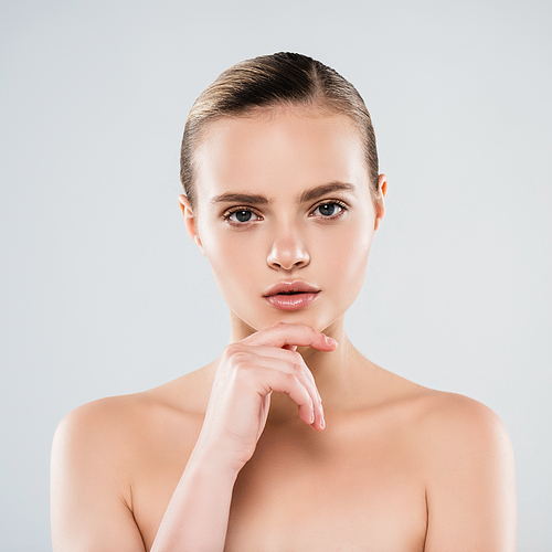 naked young woman  and touching face isolated on grey