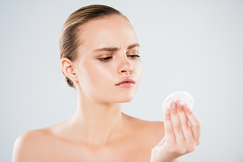 naked young woman looking at cotton pad isolated on grey