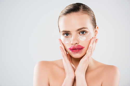 naked woman with lip mask and eye patches touching clean face isolated on grey