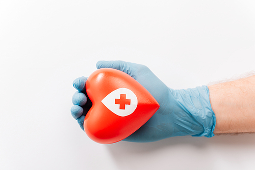 cropped view of male hand in latex glove with red heart on white, blood donation concept