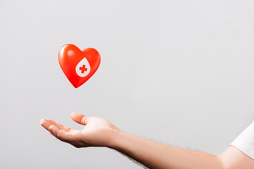 cropped view of male hand and red heart isolated on white, blood donation concept