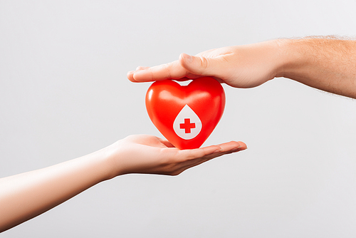 cropped view of man and women with red heart isolated on white, blood donation concept