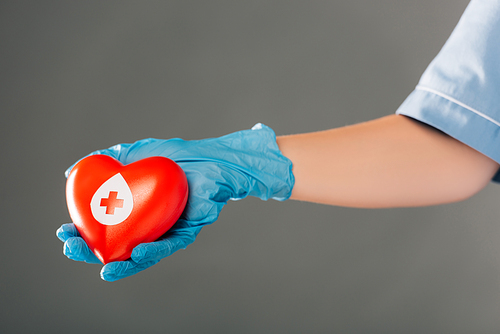 cropped view of doctor holding red heart isolated on grey, blood donation concept