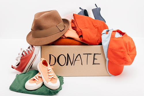 cardboard box with donated accessories, clothes and footwear isolated on white, charity concept