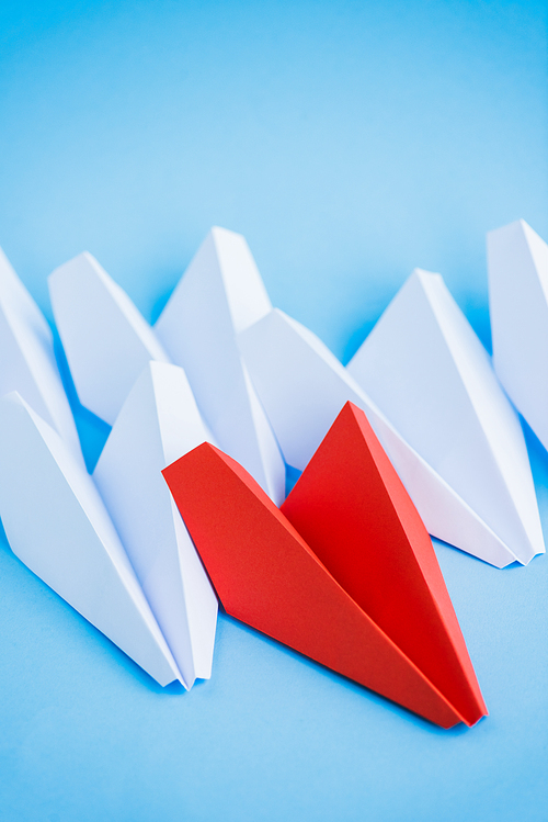 white and red paper planes on blue background, leadership concept