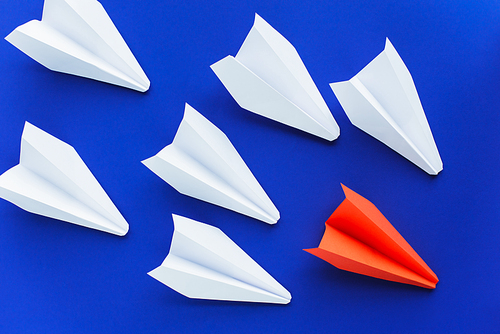 top view of white and red paper planes on blue background, leadership concept