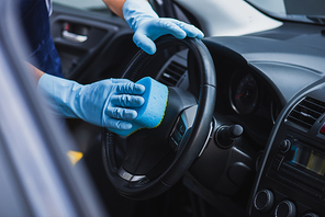 selective focus of car cleaner wiping steering wheel with sponge