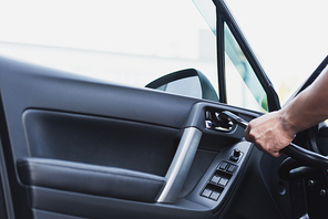 cropped view of car cleaner vacuuming car door