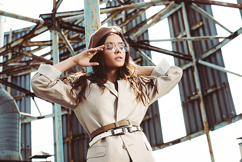 attractive fashionable girl posing in beige suit and beret on roof