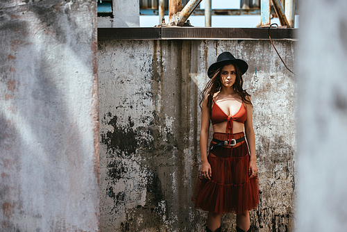 beautiful girl posing in red skirt, bra and hat on roof