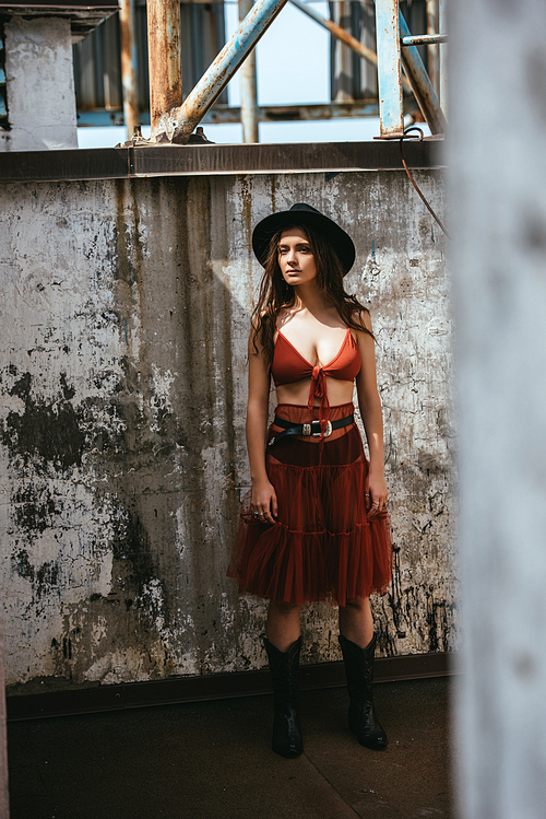 attractive fashionable girl posing in red skirt, bra and hat on roof