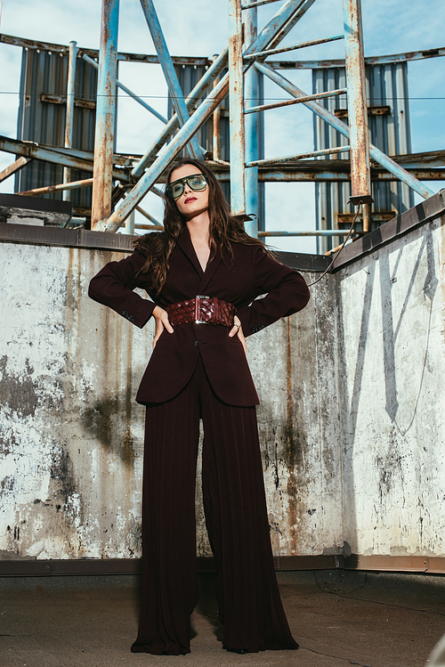 attractive elegant model posing in trendy burgundy suit on urban roof