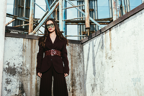 beautiful elegant model posing in trendy burgundy suit on urban roof