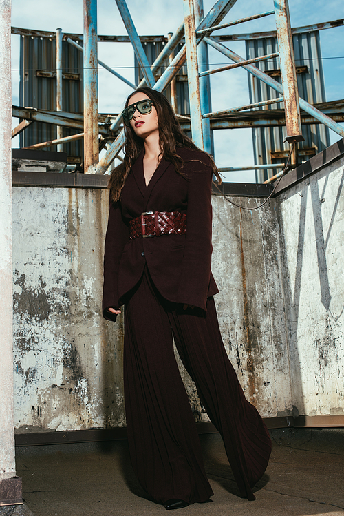 beautiful model posing in trendy burgundy suit on urban roof