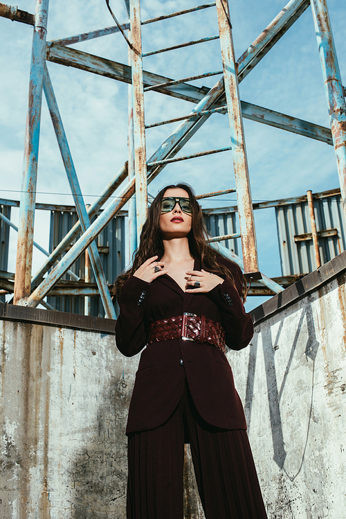 attractive model posing in trendy burgundy suit on urban roof