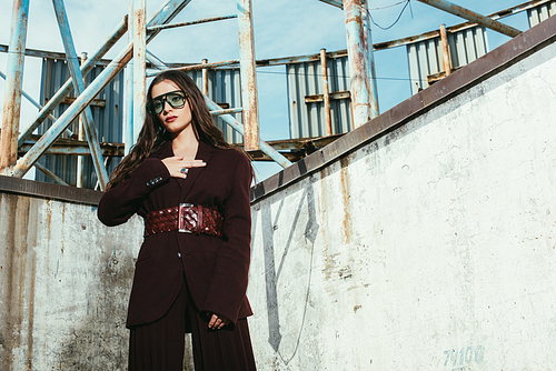 beautiful woman posing in trendy burgundy suit on urban roof