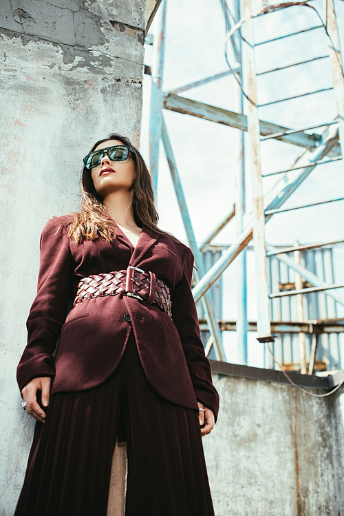 beautiful elegant model posing in trendy burgundy suit on urban roof