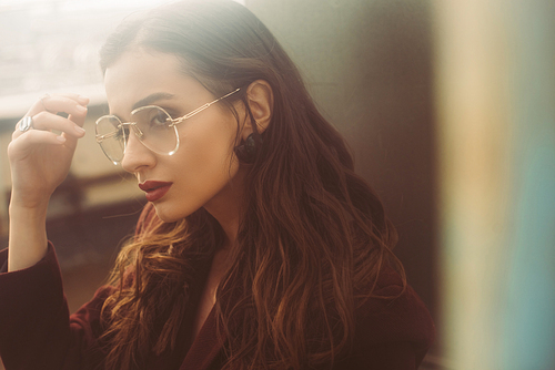 stylish elegant girl posing in trendy burgundy suit and sunglasses on urban roof