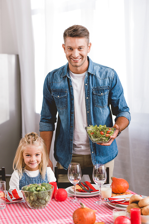 father holding salad and cute daughter smiling and  in Thanksgiving day