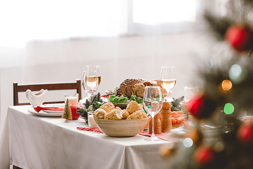 selective focus of plate with tasty turkey, corn and wine glasses on table in christmas