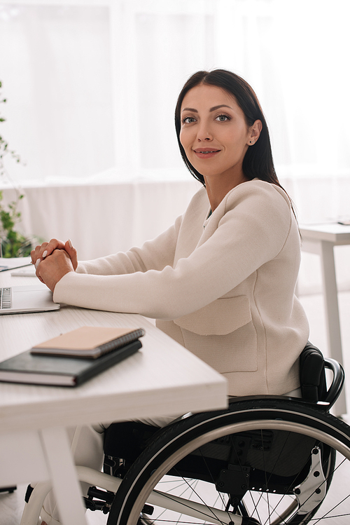 cheerful disabled businesswoman  while sitting at workplace