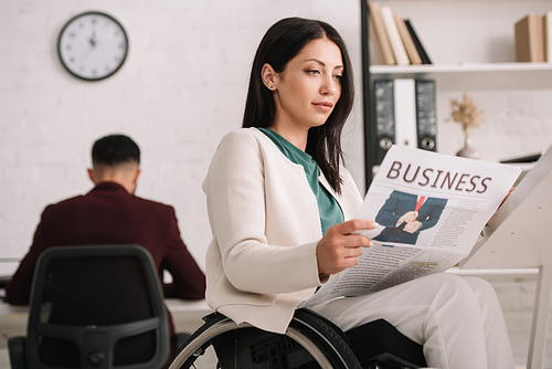 attractive disabled businesswoman reading business newspaper in office