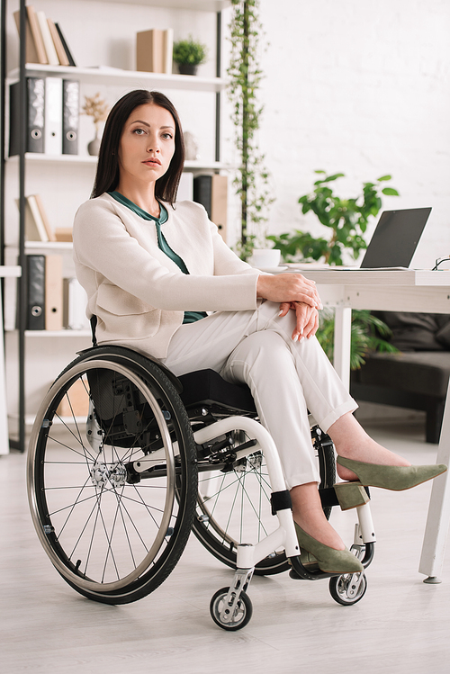 confident disabled businesswoman  while sitting in wheelchair in office