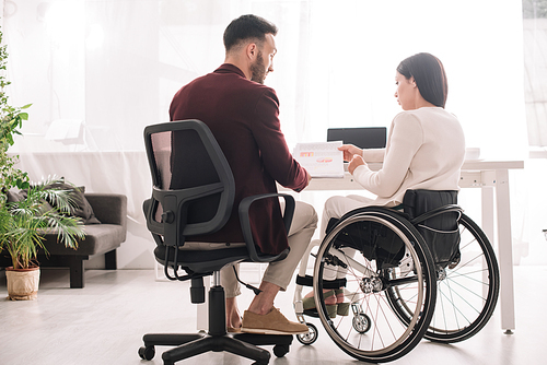 disabled businesswoman in . showing documents to business partner in office