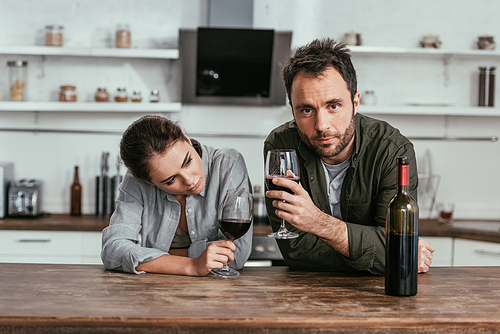 Alcohol addicted couple drinking wine on kitchen