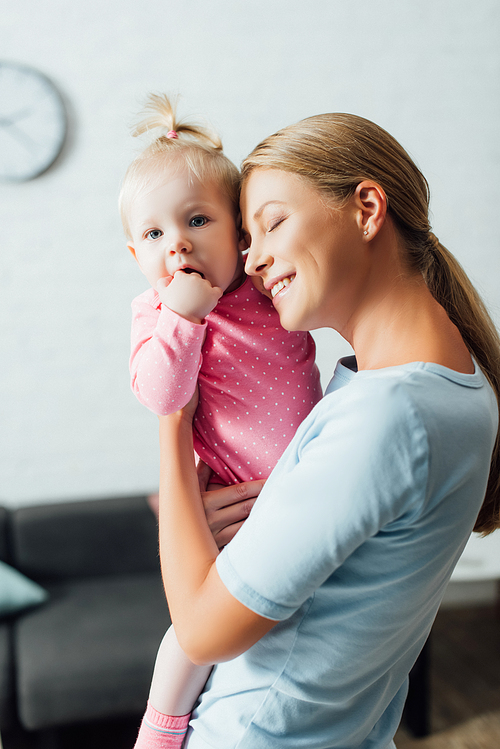 Mother with closed eye embracing child at home