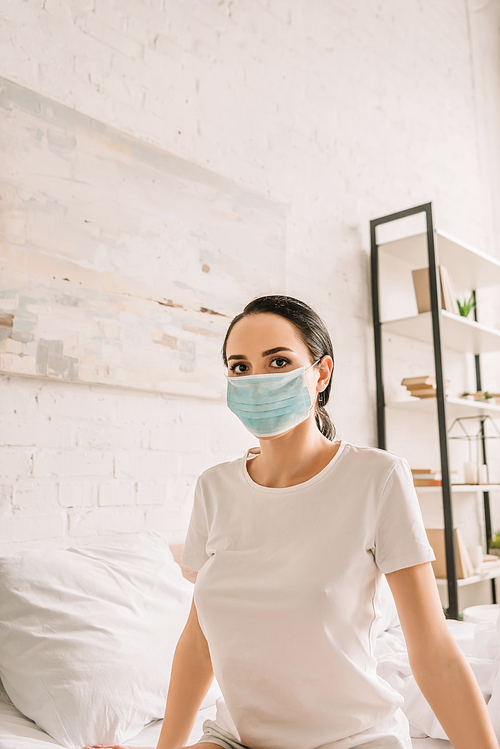 young woman in medical mask  in bedroom