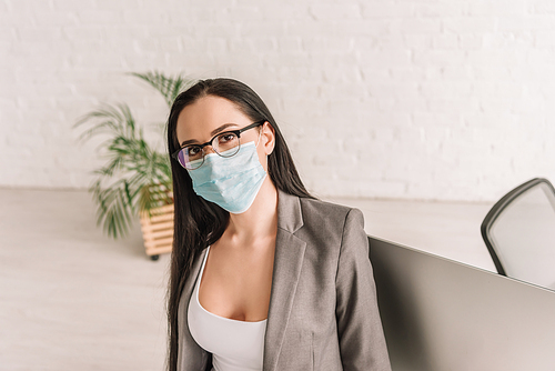 young businesswoman in medical mask  while working at home