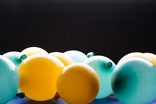 Selective focus of yellow and blue balloons isolated on black