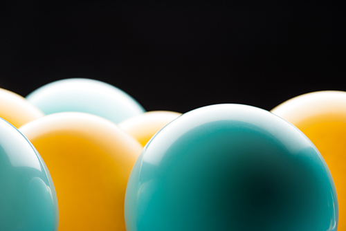 Close up view of yellow and blue bright balloons isolated on black