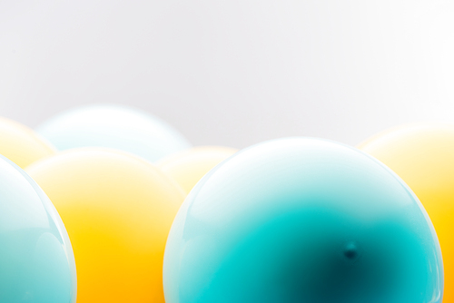 Close up view of blue and yellow balloons isolated on grey