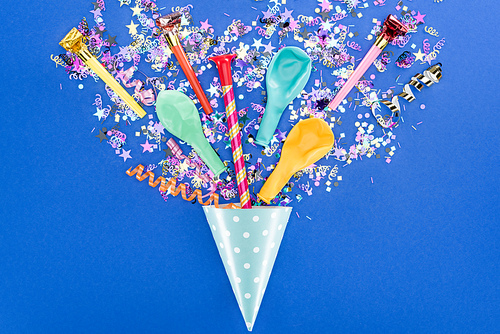 Top view of party colorful decoration on blue background, surprise concept