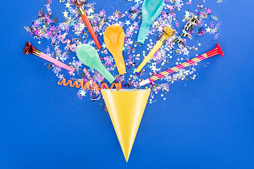 Top view of party hat on blue background, surprise concept