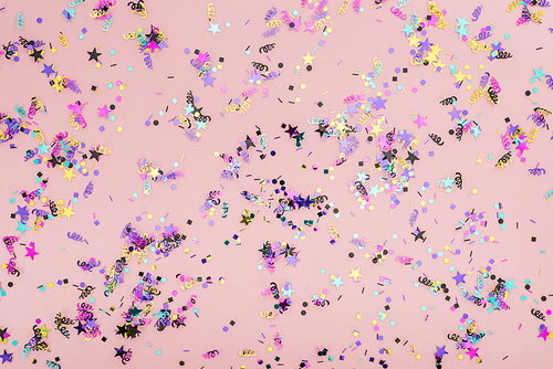 Top view of colorful confetti on pink party background