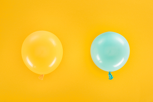 Top view of blue and yellow balloons on yellow background