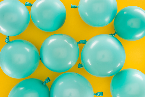 Top view of blue balloons on yellow festive background