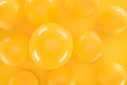 Top view yellow balloons on yellow background