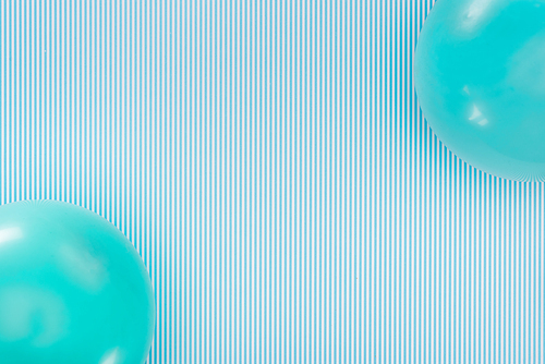 Top view of blue balloons on striped blue background